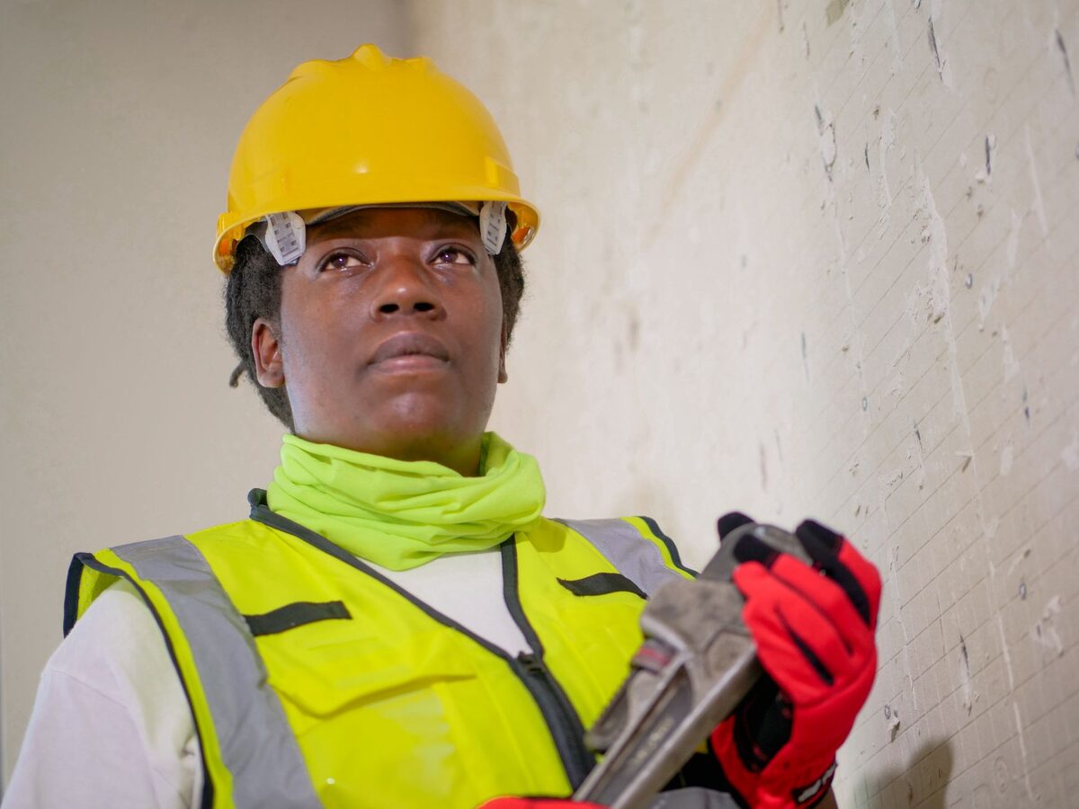 A worker in a hard hat and safety vest on site.